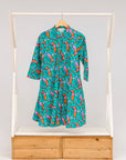 Display of teal dress with pink and orange shrimp print.