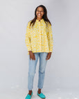 Model wearing yellow long sleeve shirt with white leaf print.