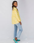 Model wearing yellow long sleeve shirt with white leaf print.