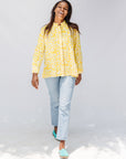 Model wearing yellow long sleeve shirt with white leaf print.
