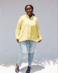 Model wearing yellow long sleeve shirt with white leaf print.