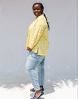 Model wearing yellow long sleeve shirt with white leaf print.
