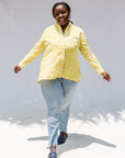 Model wearing yellow long sleeve shirt with white leaf print.