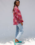 Model wearing red shirt with orange and white gumball print.