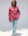 Model wearing red shirt with orange and white gumball print.