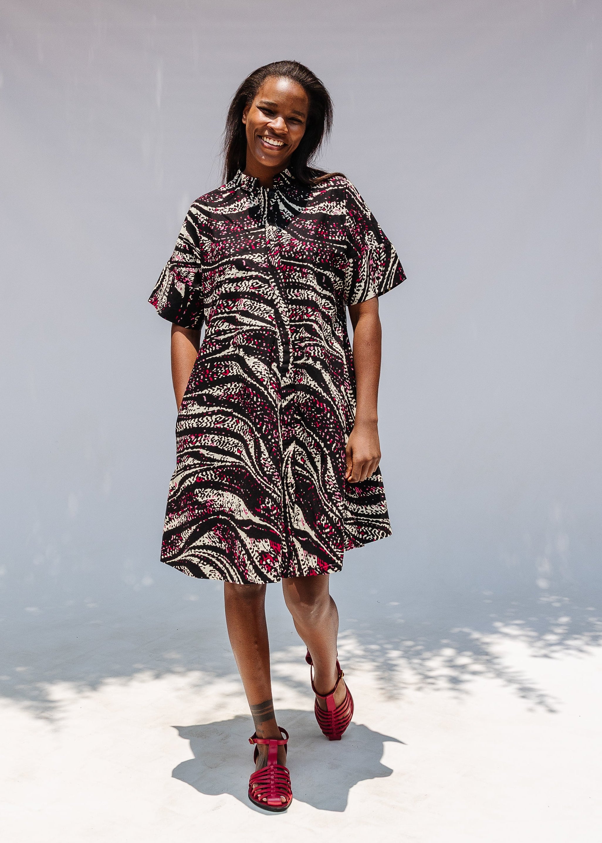 Model wearing pink, black and white glitter print dress