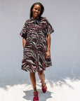 Model wearing pink, black and white glitter print dress