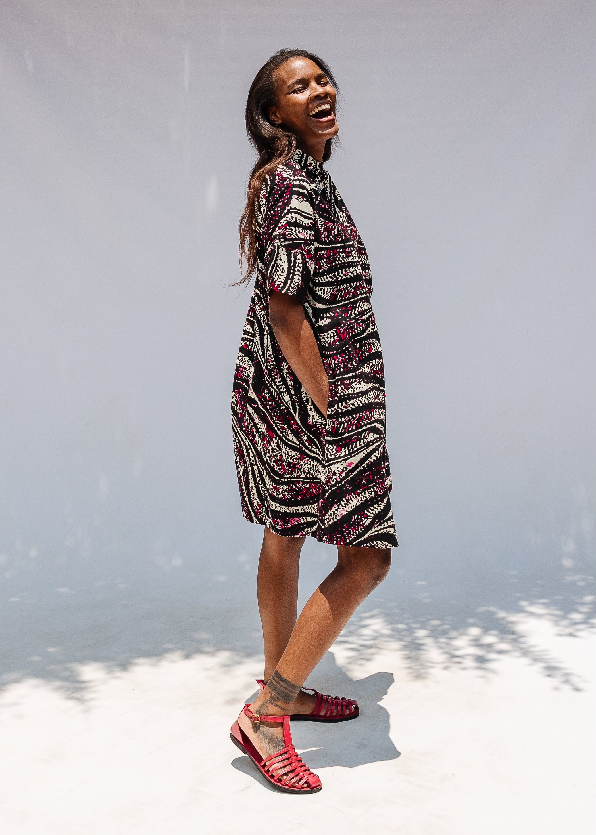 Model wearing pink, black and white glitter print dress