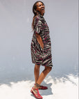 Model wearing pink, black and white glitter print dress