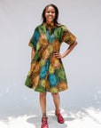 Model wearing black dress with orange, yellow, blue and green swirls.