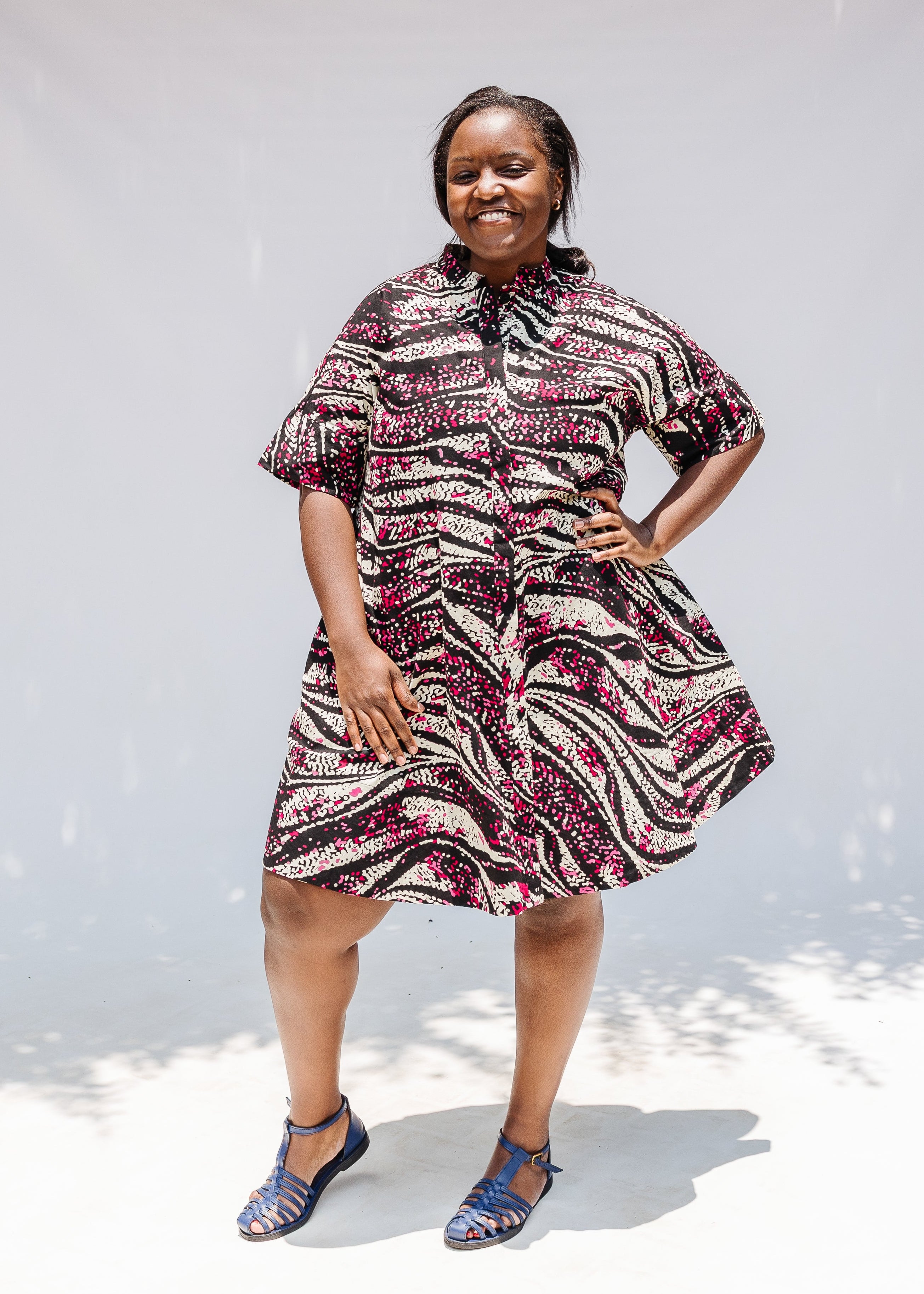 Model wearing pink, black and white glitter print dress