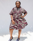 Model wearing pink, black and white glitter print dress