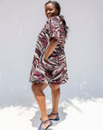 Model wearing pink, black and white glitter print dress