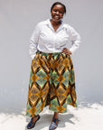Model wearing orange and green geometric print pants.