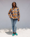 Model wearing orange, navy and white geometric print shirt.