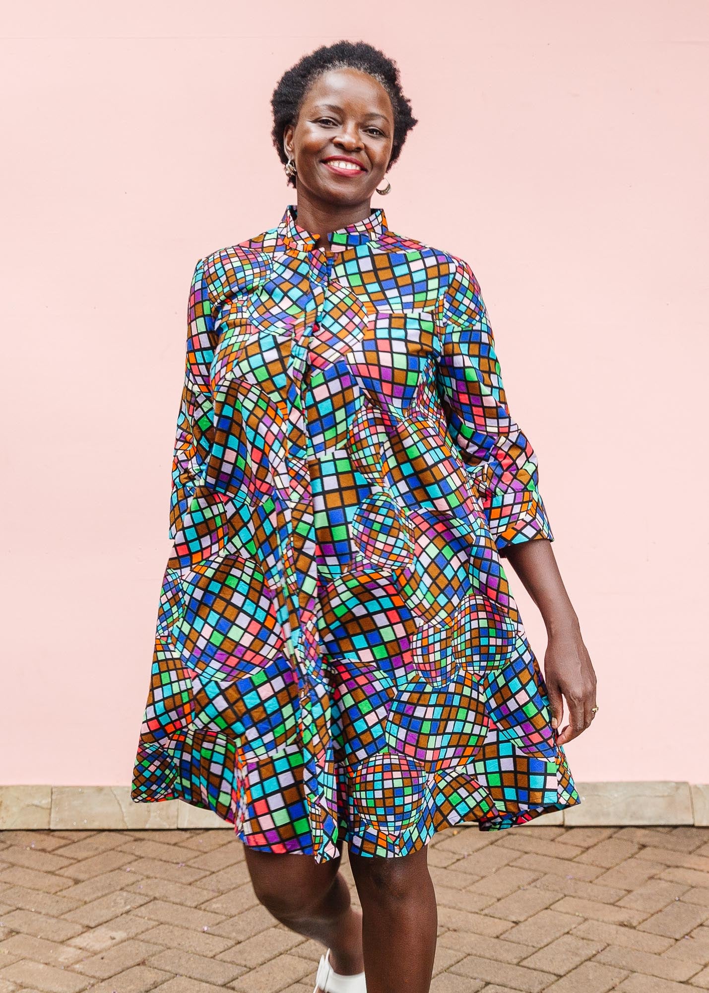 The model is wearing multi colored dress with disco ball print