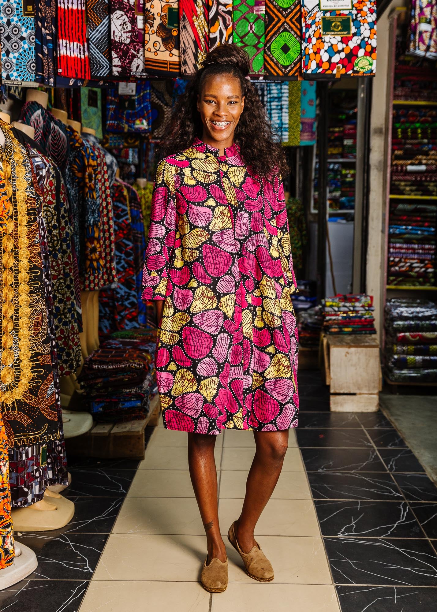 The model is wearing black, white, yellow, brown, pink, hot pink and purple bubble print dress