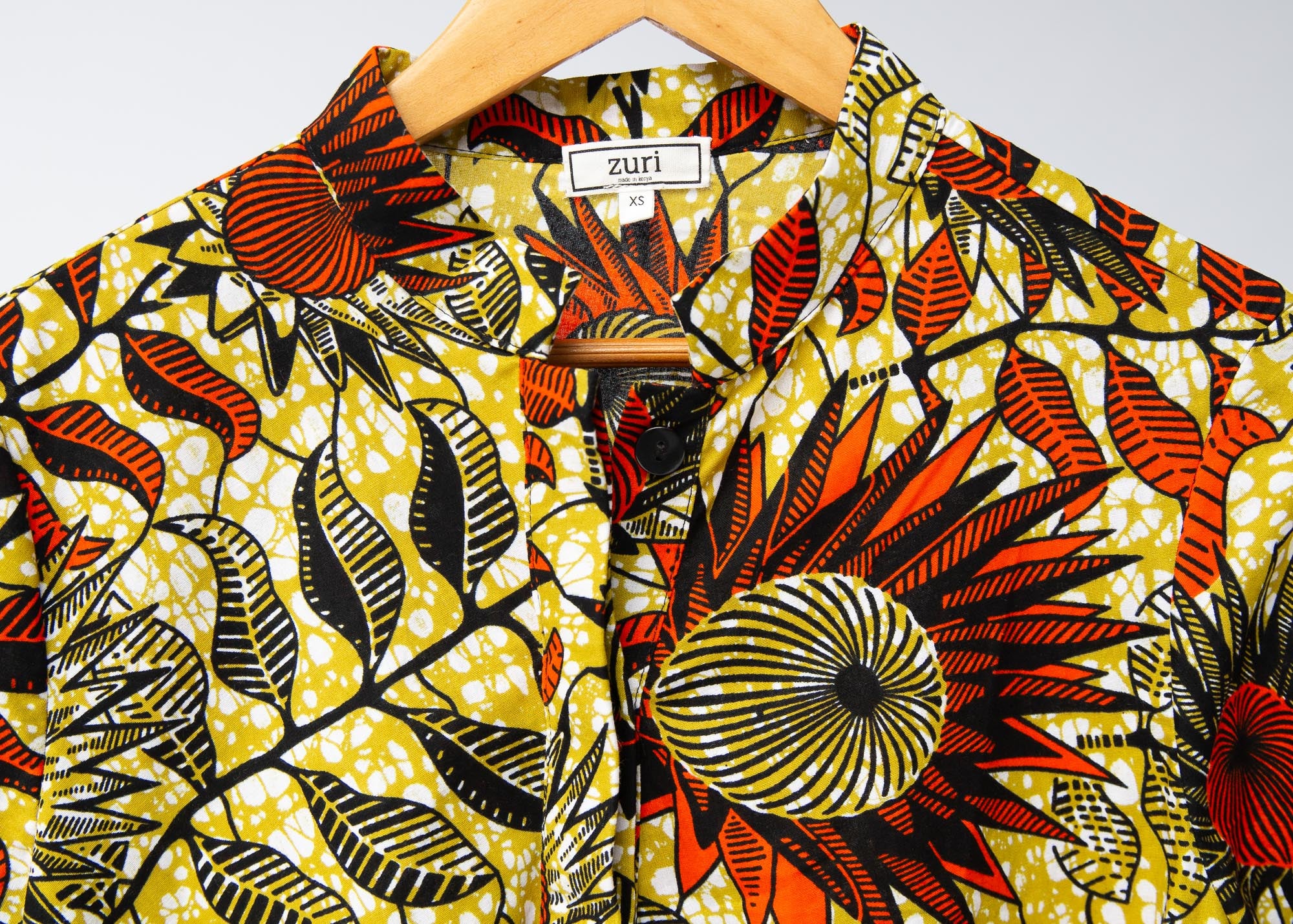 Display of white and chartreuse dress with orange and black sunflowers