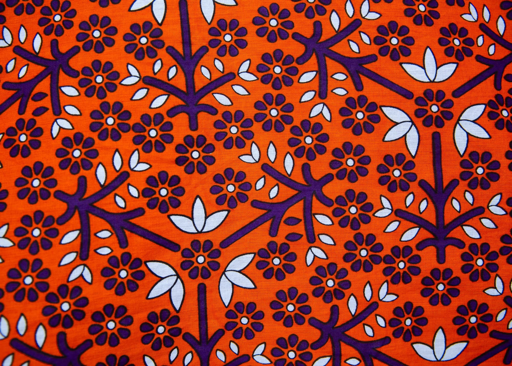 Close up display of orange, purple, white and black mixed pattern kanga tank