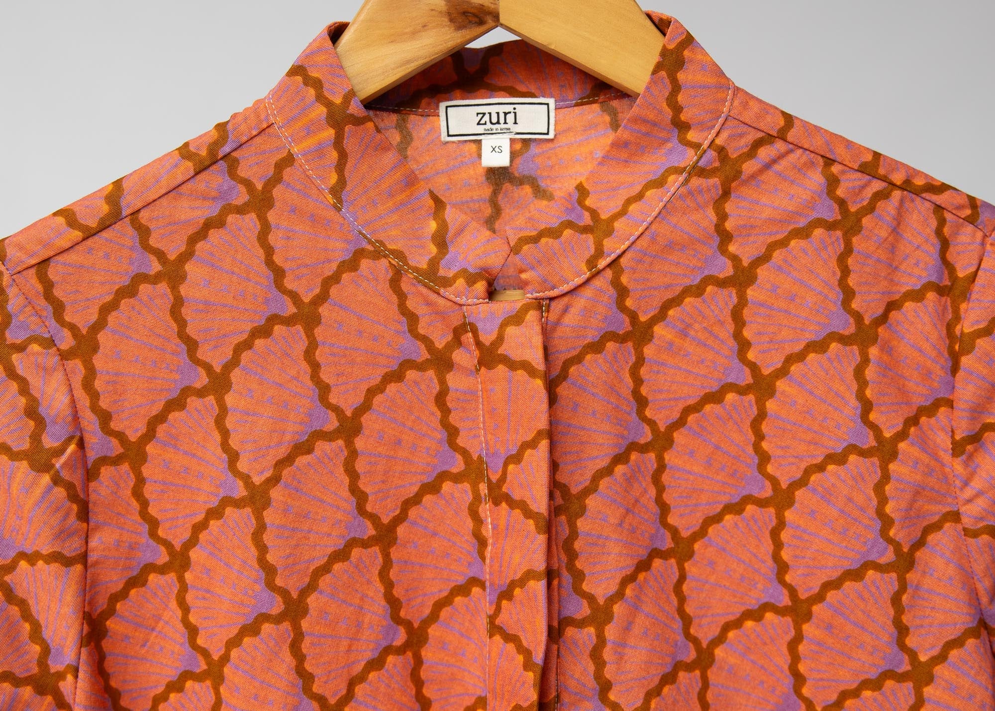 Display of peach-pink, lavender and brown seashell print dress