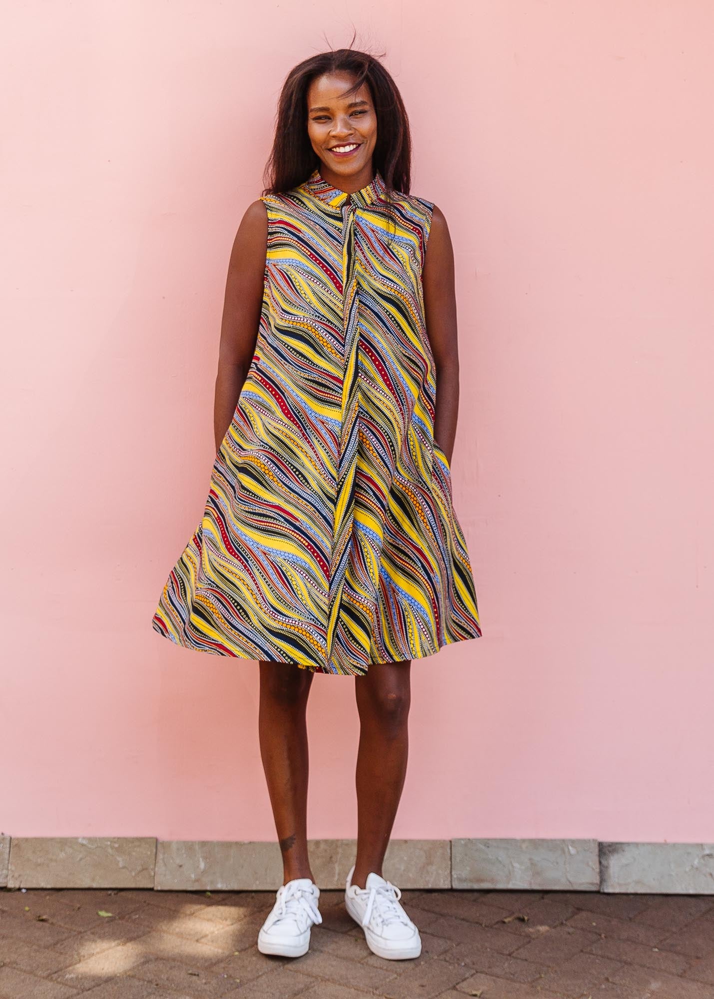 The model is wearing multi-colored abstract print dress