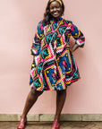 The model is wearing multi colored geometric print dress