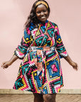 The model is wearing multi colored geometric print dress