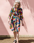 The model is wearing multi colored geometric print dress