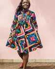 The model is wearing multi colored geometric print dress