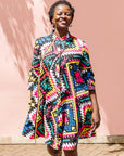 The model is wearing multi colored geometric print dress