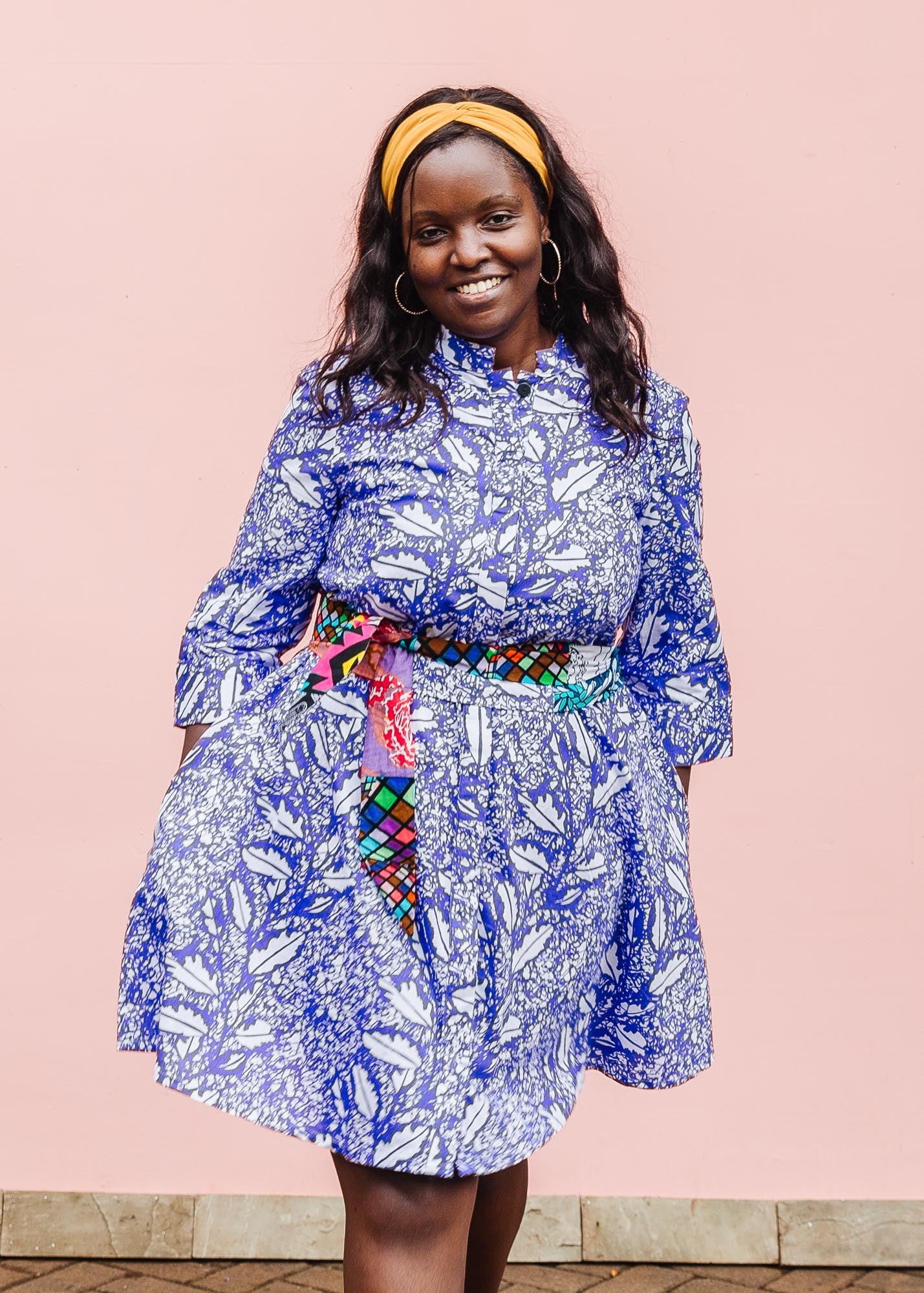 The model is wearing violet and white leaf print dress