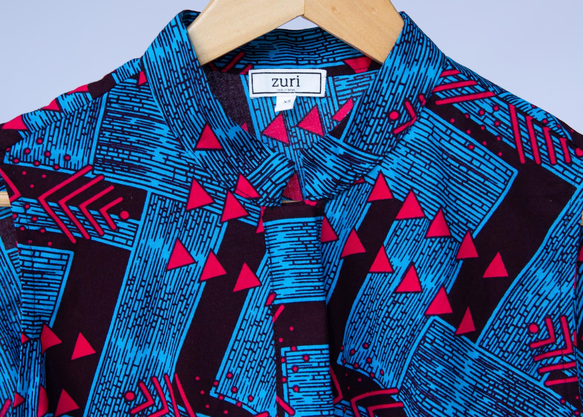 Display of black, blue and hot pink geometric print dress