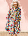 The model is wearing multi colored geometric print dress