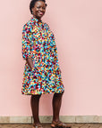 The model is wearing multi colored geometric print dress