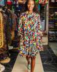 The model is wearing multi colored geometric print dress