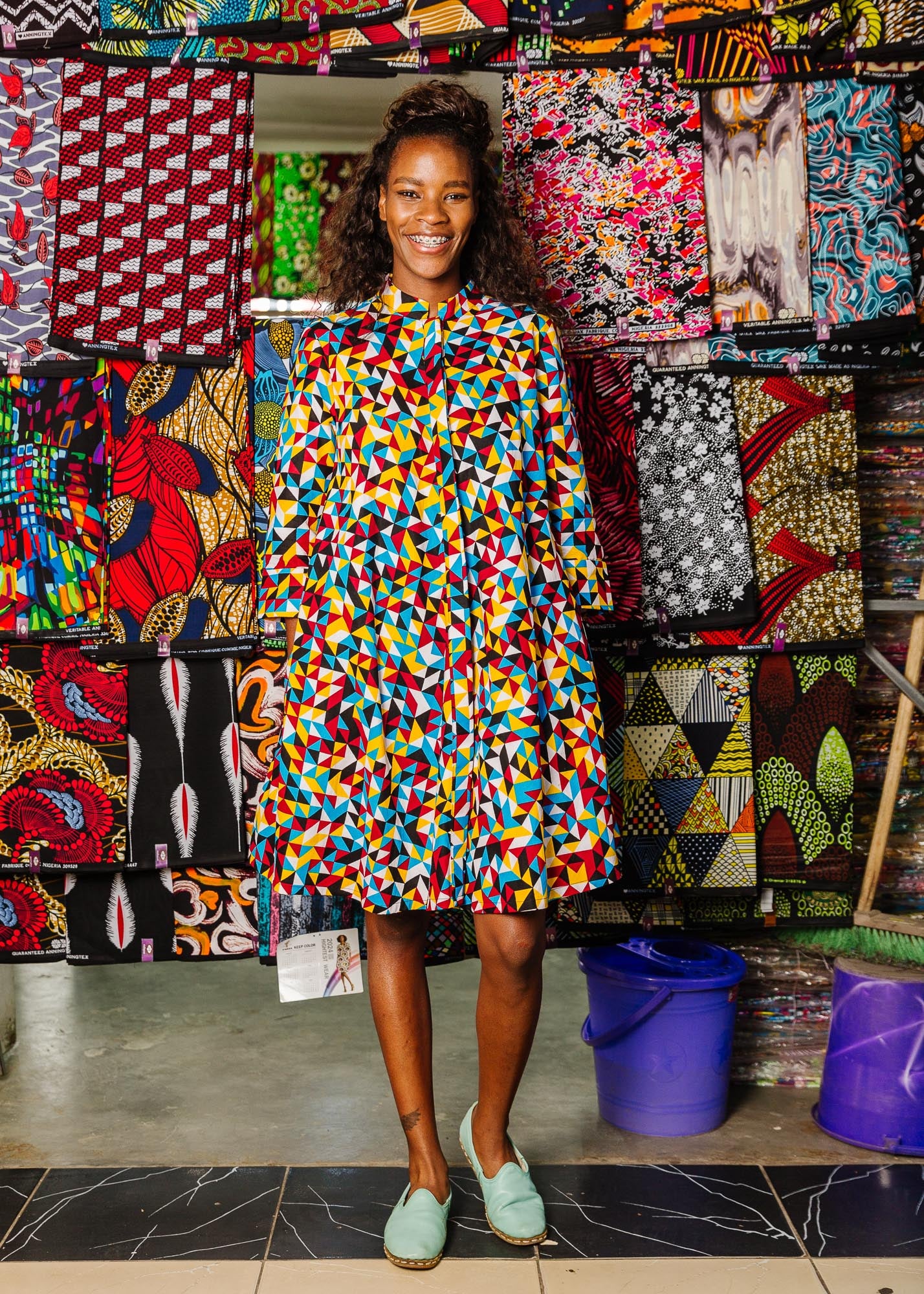 The model is wearing multi colored geometric print dress