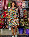 The model is wearing multi colored geometric print dress