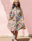 The model is wearing multi colored geometric print dress