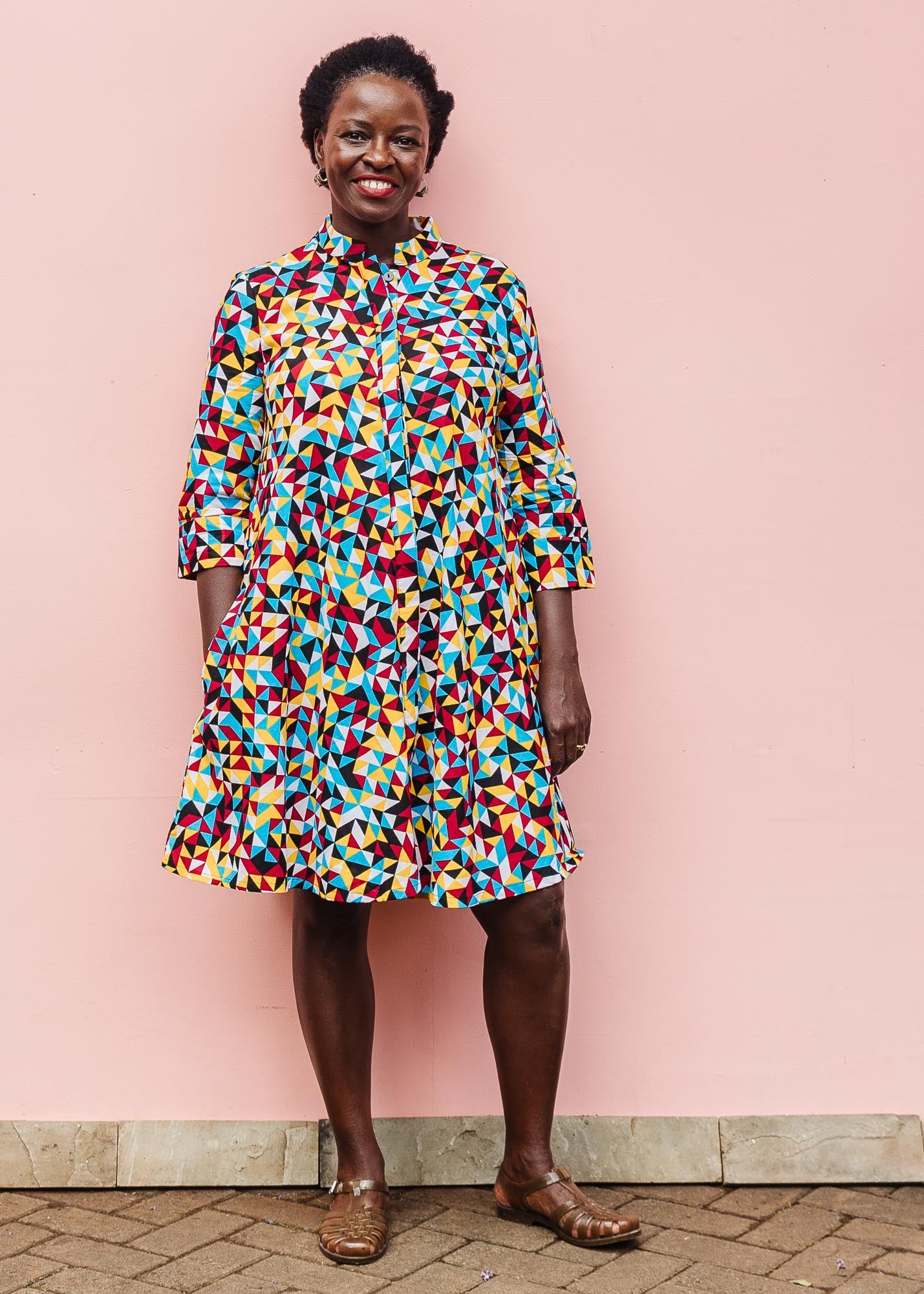 The model is wearing multi colored geometric print dress