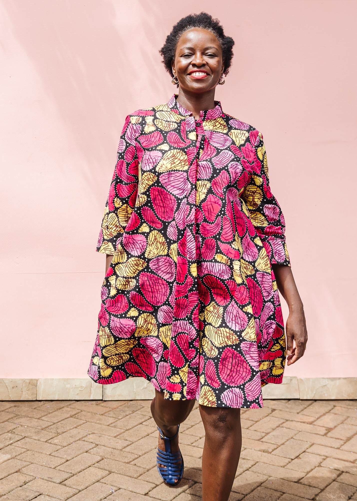 The model is wearing black, white, yellow, brown, pink, hot pink and purple bubble print dress
