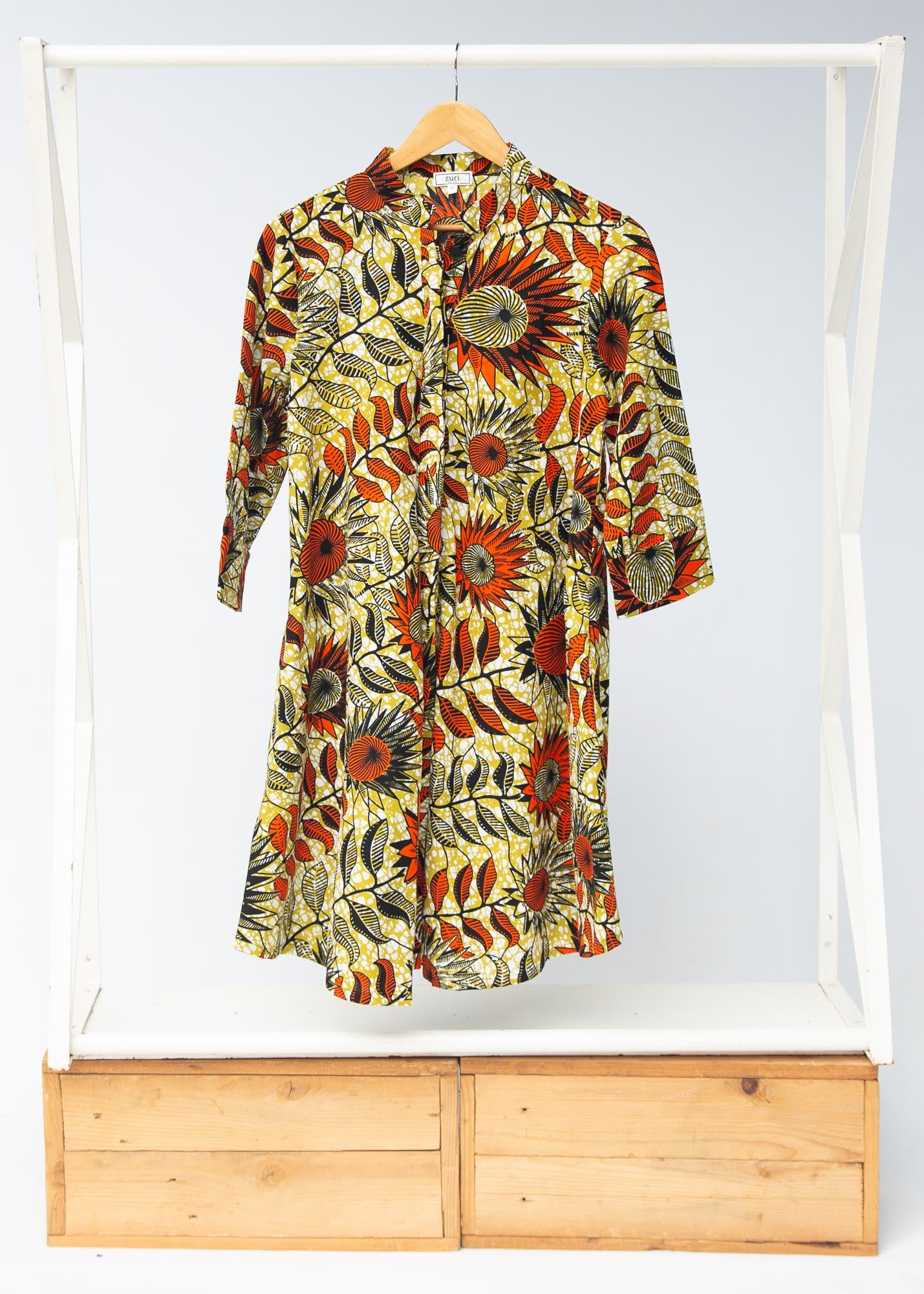 Display of white and chartreuse dress with orange and black sunflowers
