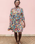 The model is wearing multi colored geometric print dress