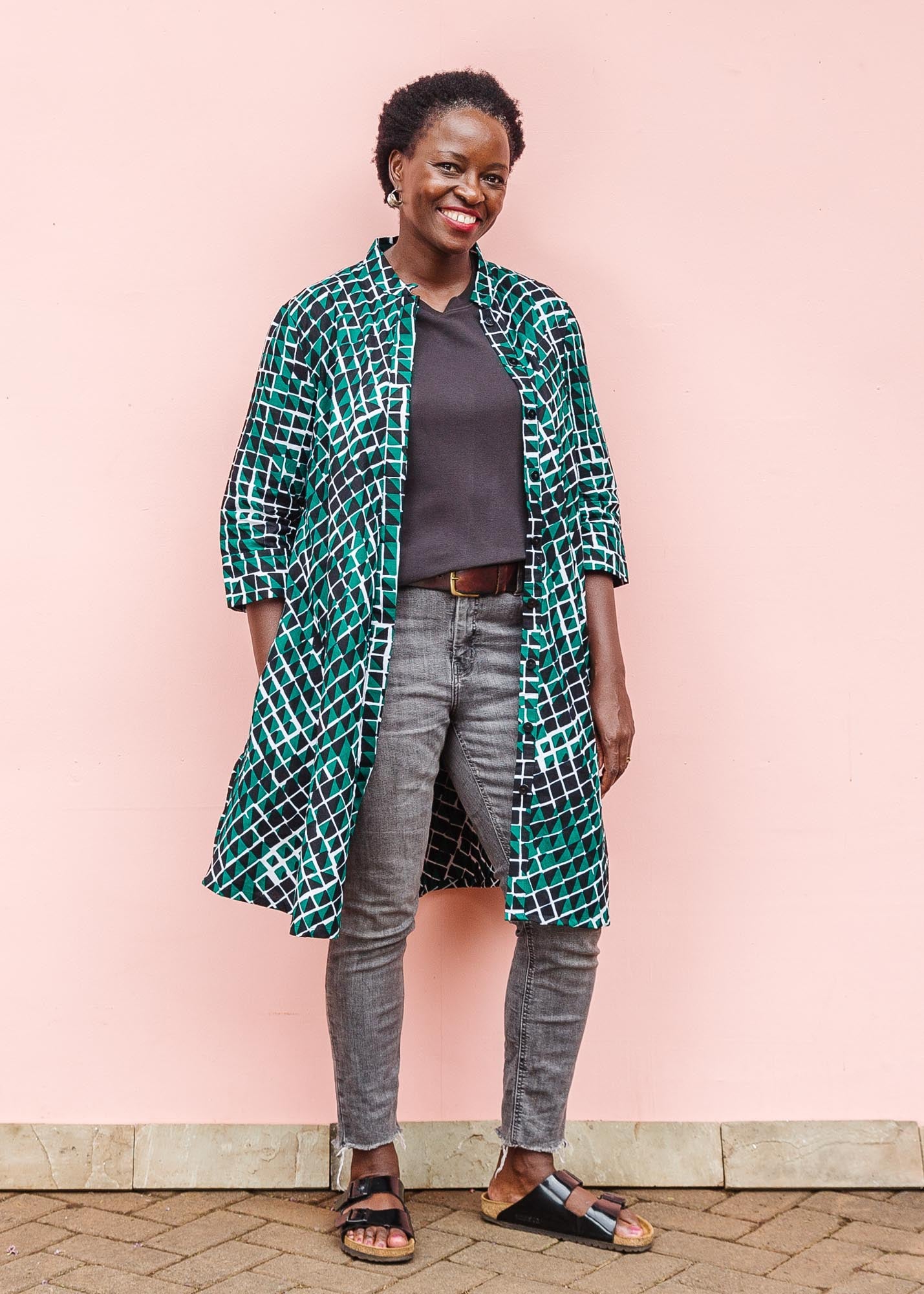 The model is wearing black, green and white geometric print dress