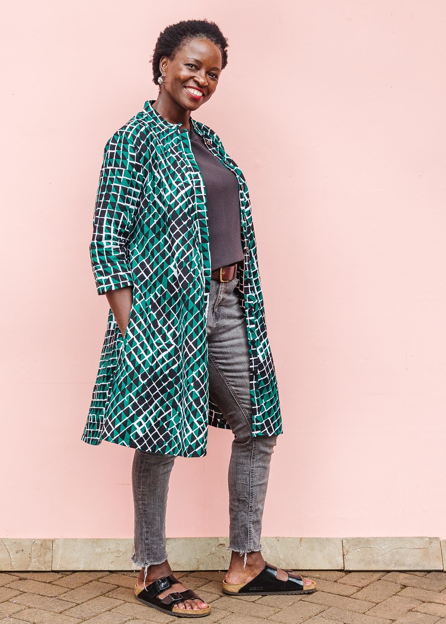 The model is wearing black, green and white geometric print dress