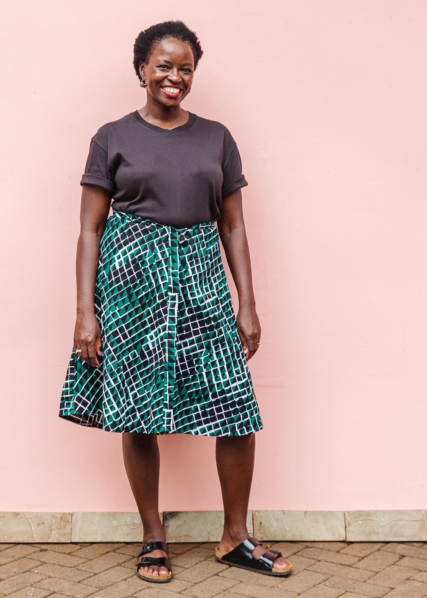 The model is wearing black, green and white geometric print dress