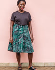 The model is wearing black, green and white geometric print dress