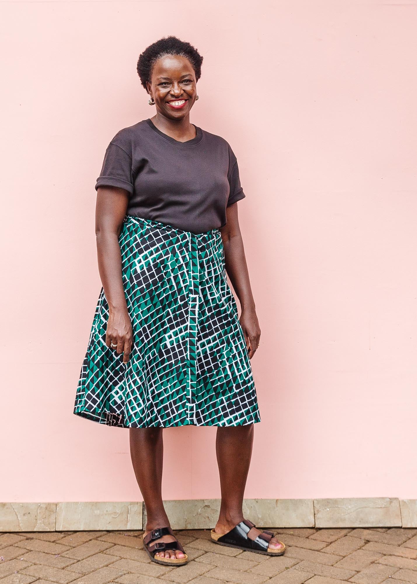 The model is wearing black, green and white geometric print dress