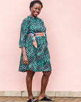 The model is wearing black, green and white geometric print dress