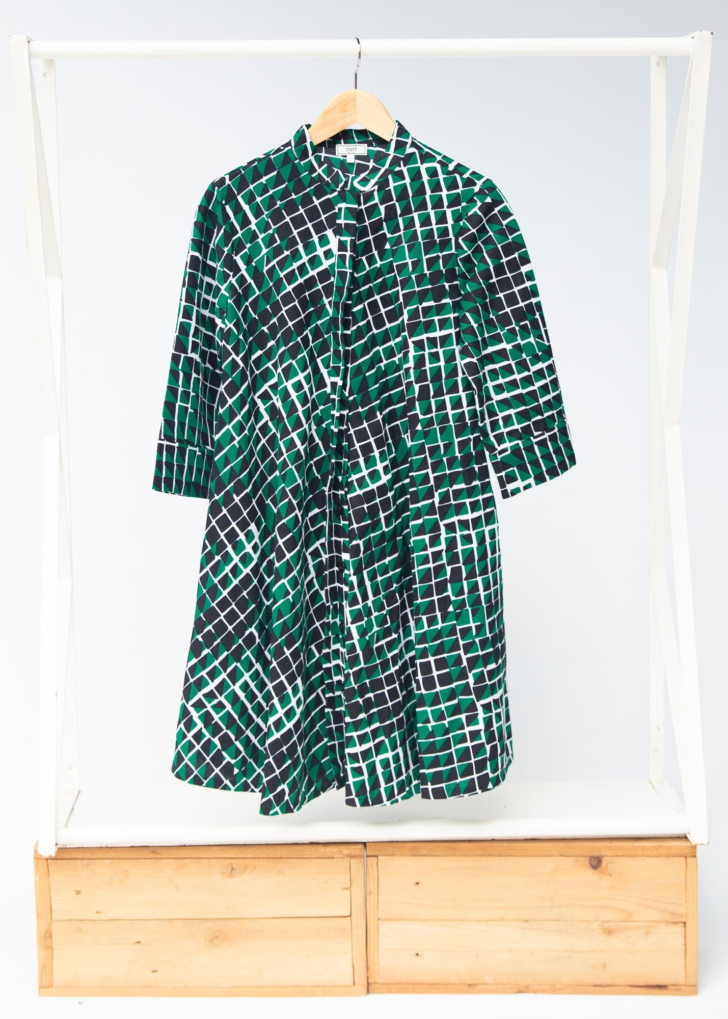 Display of black, green and white geometric print dress