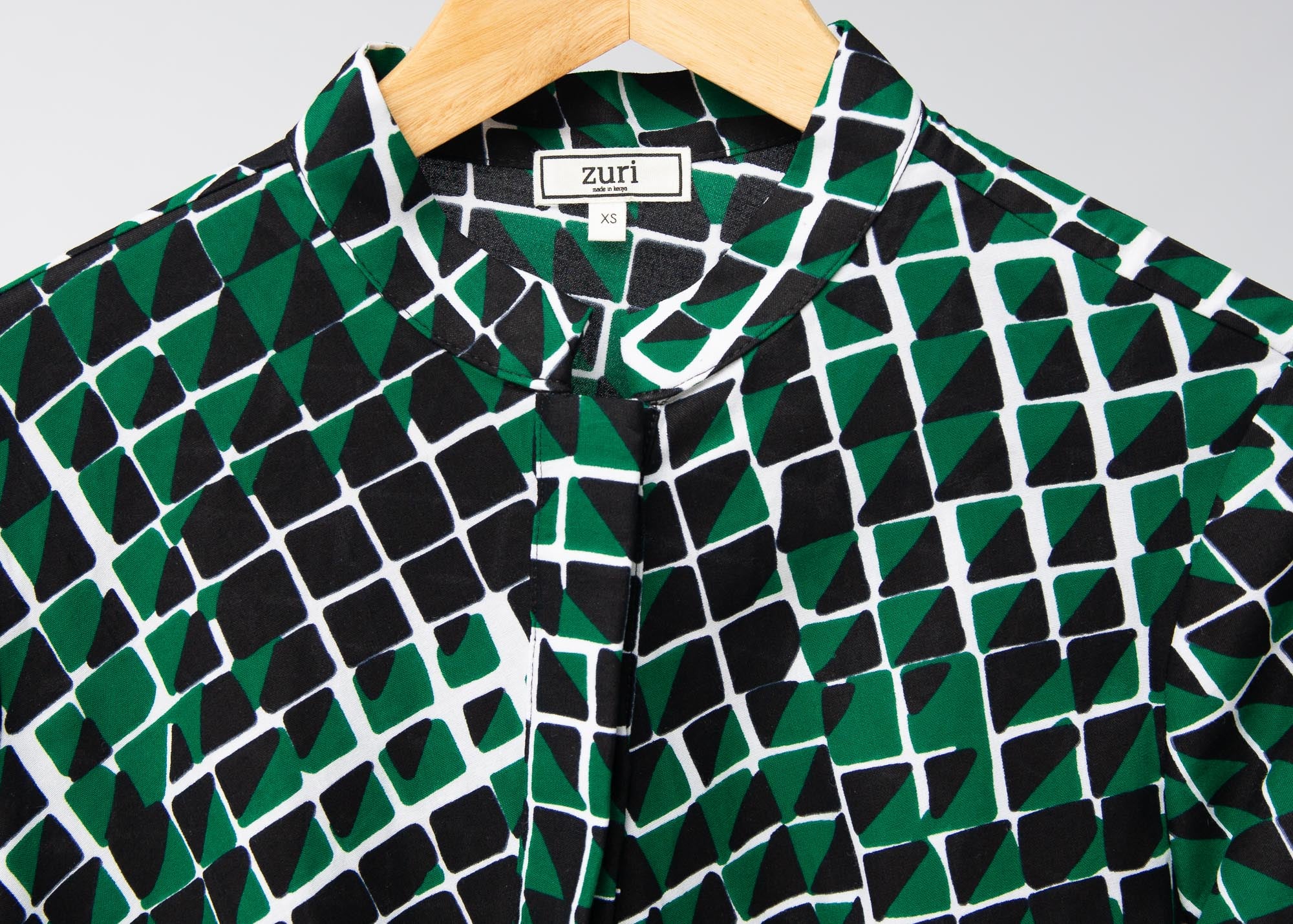 Display of black, green and white geometric print dress